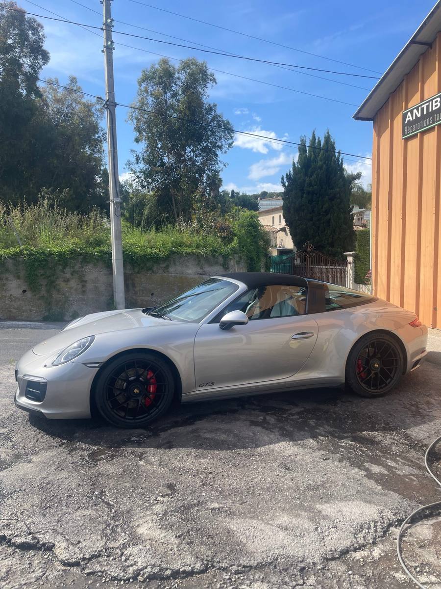 Porsche 911 Targa GTS argent garée le long de l'atelier